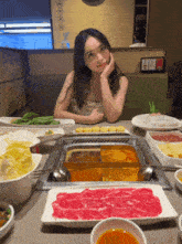 a woman sitting at a table with plates of food and a sign that says ' a ' on it
