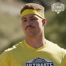 a man wearing a yellow shirt with canada 's ultimate challenge written on it