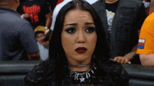a woman wearing red lipstick and a necklace with the letter p on it