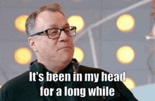 a man wearing glasses and headphones says " it 's been in my head for a long while "