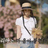 a woman wearing a hat and a white shirt is walking down a sidewalk .