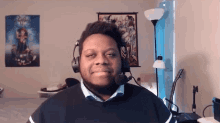 a man wearing headphones and a microphone is smiling for the camera