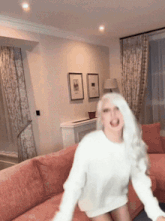 a woman with white hair is sitting on a red couch