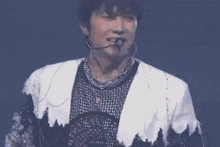 a close up of a man wearing a microphone and a necklace .