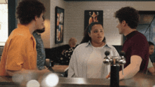 a group of people standing around a counter talking