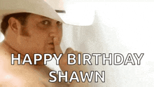 a shirtless man in a cowboy hat is holding his finger to his lips and saying `` happy birthday shawn '' .