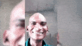 a man with a bald head is smiling and wearing ear buds .