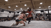 two women in a wrestling ring with a sign that says kenedy on it