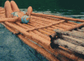 a woman in a bikini is laying on a bamboo raft in the water with a blue swim cap that says ' ocean '