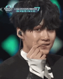 a close up of a person 's face with a kcon mexico sign in the background
