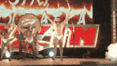 a naked man stands on a stage in front of a osaka sign