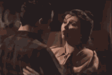 a man and woman are kissing in a dark room .