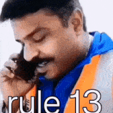 a man with a mustache is talking on a cell phone with rule 13 written on the bottom right