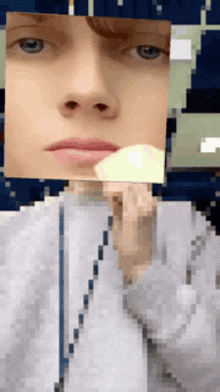 a pixelated image of a person 's face with a yellow item in front of it