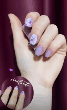 a close up of a woman 's hand with purple nail polish and a nail art design