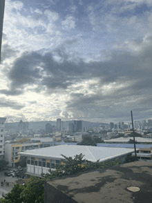 a view of a city from a rooftop with a cloudy sky