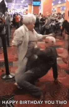 an elderly couple dancing in a crowded room with the words happy birthday you two on the bottom