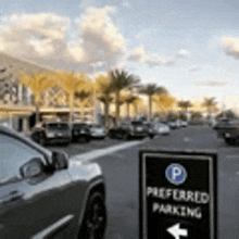 a car is parked on the side of the road next to a preferred parking sign .