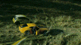 a yellow car is driving down a road with a blurred background