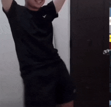 a man wearing a black shirt with a white v on the front is dancing
