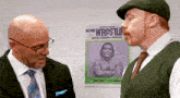 two men talking in front of a poster that says action wrestlin