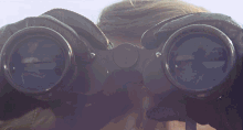 a person wearing a pair of binoculars with the letter e on them