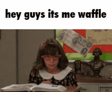 a girl wearing glasses sits at a desk reading a book with the words hey guys its me waffle above her