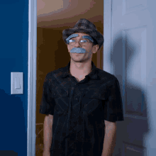 a man wearing a plaid hat and fake mustache is standing in a doorway
