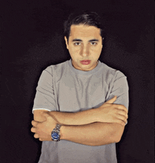 a man with a watch on his wrist is making a face