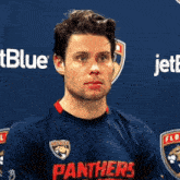 a man wearing a panthers jersey looks to the side