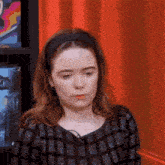 a woman wearing a headband and a plaid shirt looks down