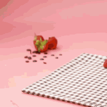 a person is putting a strawberry on top of a chocolate cookie on a wooden cutting board