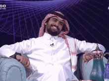 a man in a white shirt is sitting in front of a screen that says " channels " on it