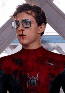 a man wearing glasses and a spider man suit has a bloody nose