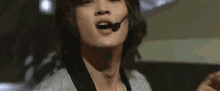 a close up of a person wearing a microphone on their mouth .