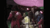 a group of people are singing into microphones in a dark room