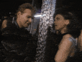 a man and a woman are looking at each other