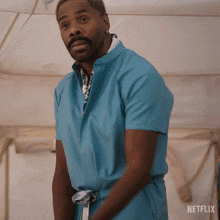 a man in a blue shirt is standing in front of a netflix banner