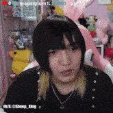 a girl with a piercing in her lip is sitting in front of a pink chair with a bunny ear