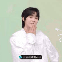 a young man in a white shirt is blowing a kiss while holding a flower .