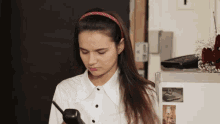 a woman in a white shirt holds a cell phone