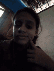 a young girl taking a selfie with her finger on her chin