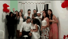 a group of people are posing for a picture in a room with balloons