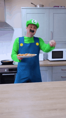 a man dressed as luigi is holding a plate of food in a kitchen