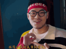 a man wearing glasses and a headband that says queer on it