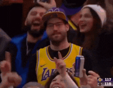 a man in a lakers jersey is giving a thumbs up