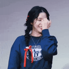 a woman wearing a blue sweatshirt that says " the studio " on it