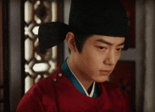 a man wearing a black hat and a red top