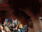 a blurry photo of a crowd of people with a sign in the background that says ' a '