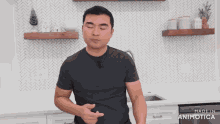 a man in a black shirt is standing in a kitchen with the words made in animatica below him
